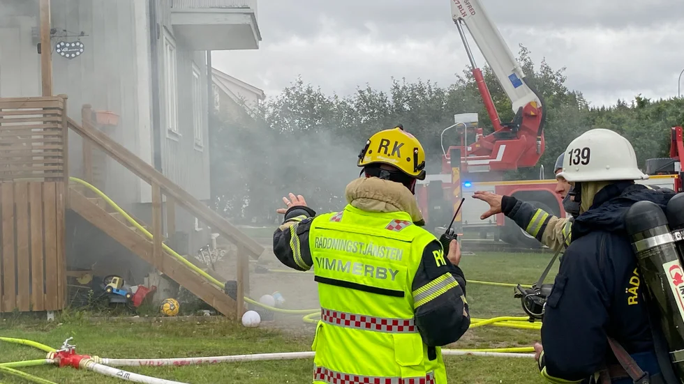Räddningspersonal diskuterar hur man bäst driver räddningsarbetet vidare, för att undvika att branden i källaren får fäste i villans konstruktion.