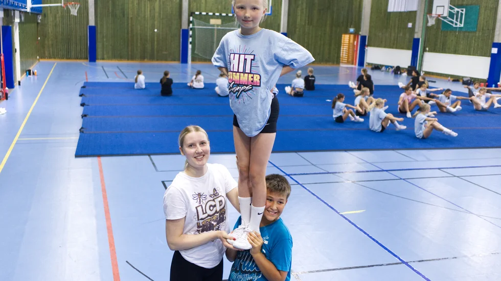 Klara Lundin, Nelly Holmgren, Miller Lundkvist i ett stunt, ett moment i cheerleading där deltagarnas mål är att bära upp en person (som kallas toppen). 