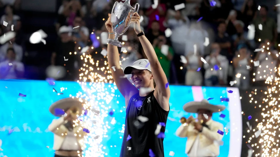 Iga Swiatek, från Polen, håller upp segerpokalen efter vinsten mot Jessica Pegula i WTA-slutspelets final.