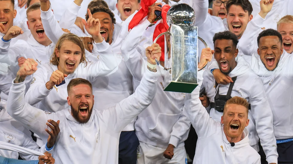Malmö FF:s lagkapten Pontus Jansson och Anders Christiansen, lagkapten innan han tvingades avbryta säsongen på grund av hjärtproblem, lyfter Lennart Johanssons pokal.