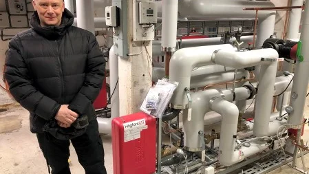 Jonas Pettersson, vvs-ingenjör på Piteå kommun, bredvid den nya returvärmeväxlaren som är installerad i Öjeby sport-och simhall.