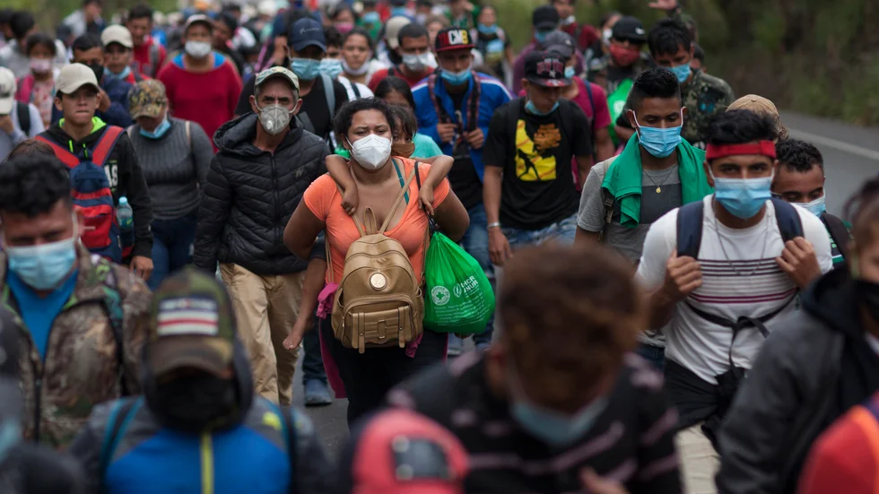 Tusentals migranter är på väg till fots från Centralamerika till USA. Här bär en kvinna från Honduras sitt barn på ryggen på en motorväg i Chiquimula, Guatemala.