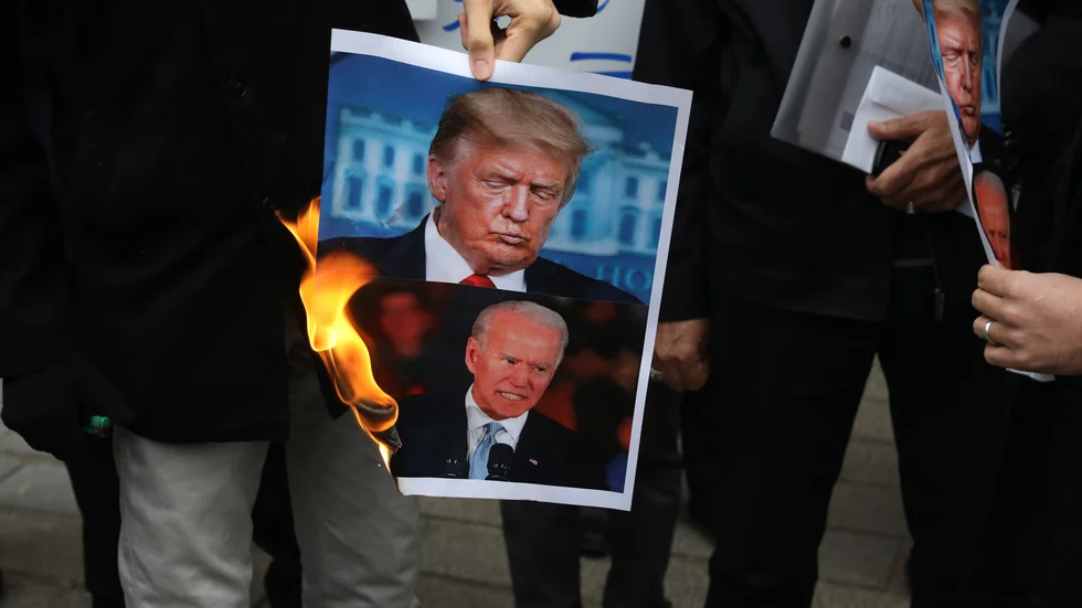 Demonstranter bränner en bild på USA:s president Donald Trump och tillträdande president Joe Biden under en protest framför det israeliska utrikesdepartementet i lördags – dagen efter mordet på Mohsen Fakhrizadeh.