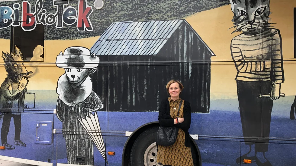 Anneli Furmark framför Umeå Kommuns biblioteksbuss som hon gjorde exteriören till ifjol.