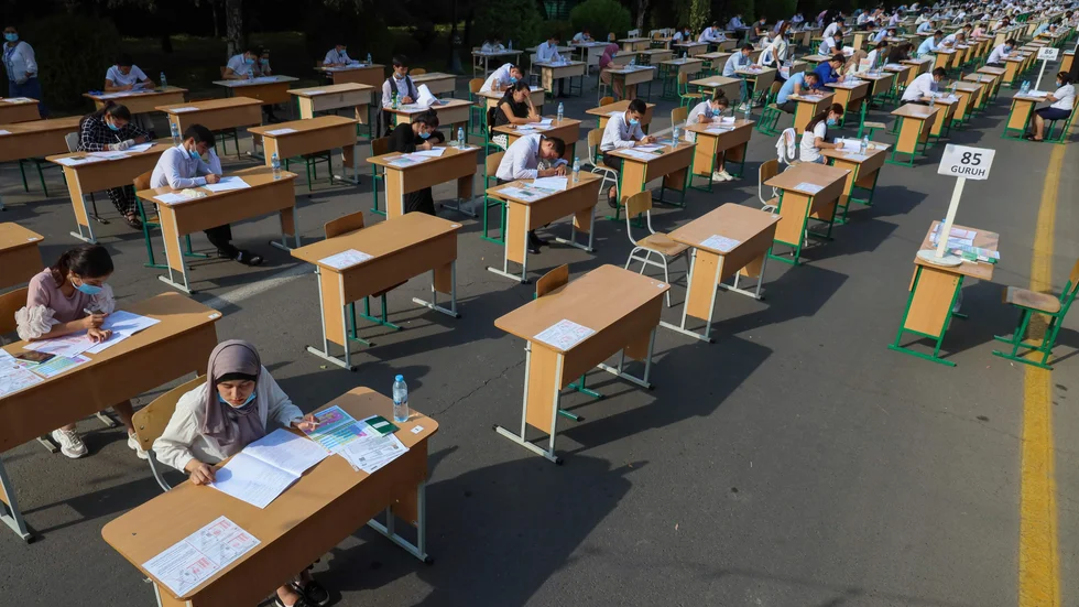 Uzbekiska studenter skriver årets inträdesprov till universiteten utomhus i huvudstaden Tasjkent.