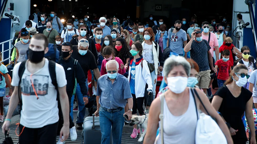 Passagerare med ansiktsmasker går av en färja Pireus utanför Atens den 20 augusti. Arkivbild.