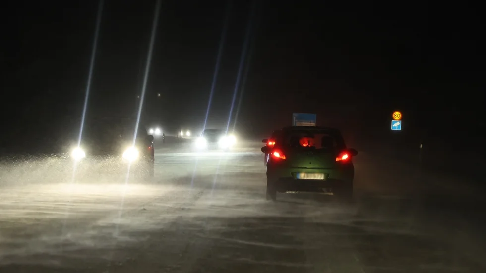 På Väg 55 blåser kraftiga sidovindar som gör att snö yr upp på vägen och tillsammans med snöfallet försämrar sikten.
