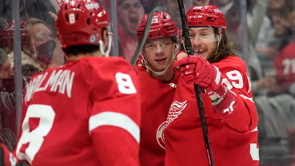 Detroits Lucas Raymond, i mitten, firar ett av sina två mål mot Ottawa med lagkamraterna Jake Walman (8) och Tyler Bertuzzi (59).