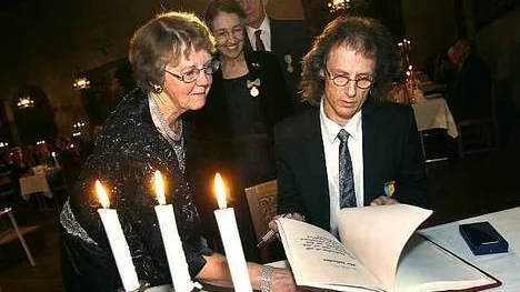 Ted Dluzewski skriver in sig i matrikeln under överinseende av Ann-Marie Peterson. I bakgrunden Ulla Fries och Hans Rosling.