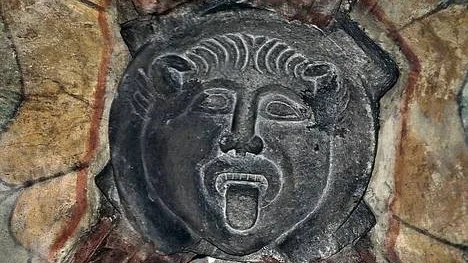 Han sitter uppe under innertaket i Helga trefaldighets kyrka i Uppsala och lipar försmädligt ned motbesökarna, djävulen på kyrkans nordsida.