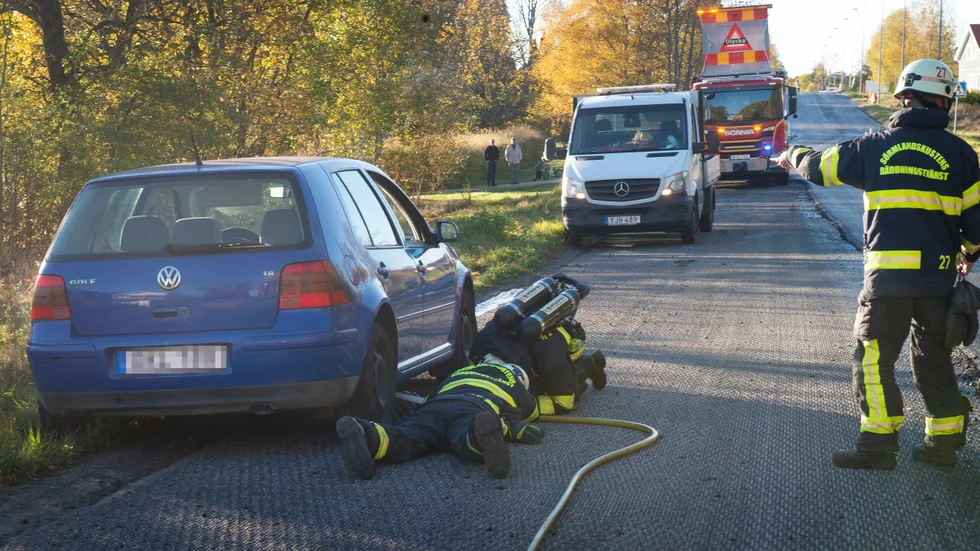 Brandmän kyler ner bilens underrede.