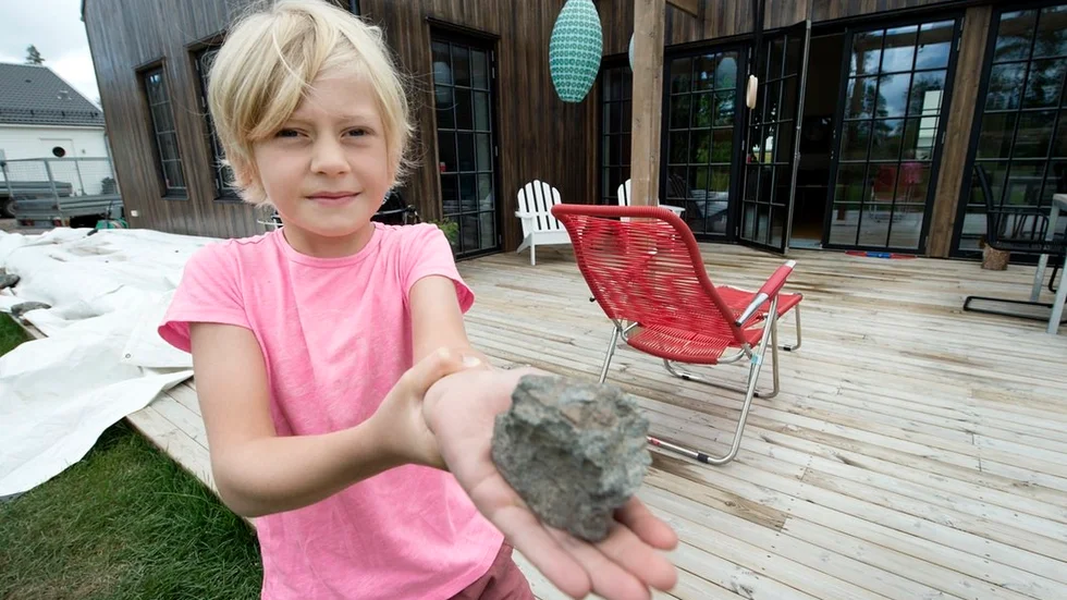Edvin, 7, son till Torun Rosén och Mårten Nilsson på Hagabergsvägen 15 i Trosa. Han visar upp en projektil som nästan träffade honom. "Jag blev jätterädd och en sten kom precis bredvid mig. Men jag sprang in så snabbt jag kunde för att inte träffas."