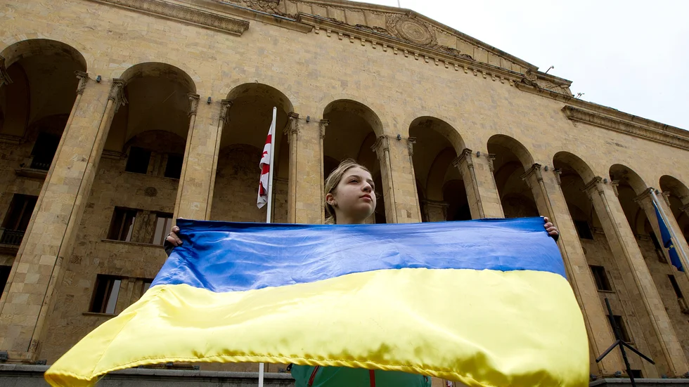 En demonstrant i Tbilisi i Georgien med en ukrainsk flagga. Arkivbild.