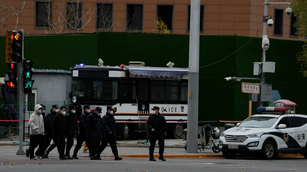Säkerhetspersonal vid en korsning i Peking där demonstrationer hölls dagen innan. Bilden togs under måndagen.