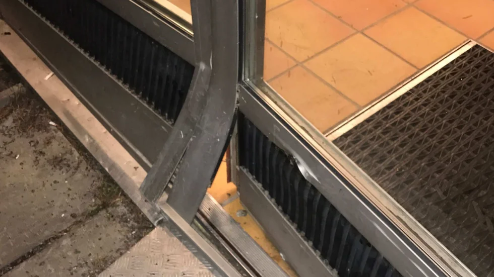 Entrédörren till hyreshuset fick skador efter krocken.