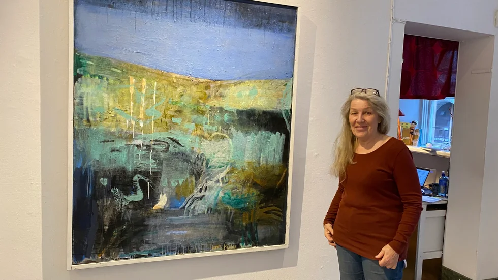 Konstnären Lena Möller med målningen "Den sommaren", med färger från sanddyner, himmel och hav i Tylösand. Utställningen visas på Galleri Kronan.