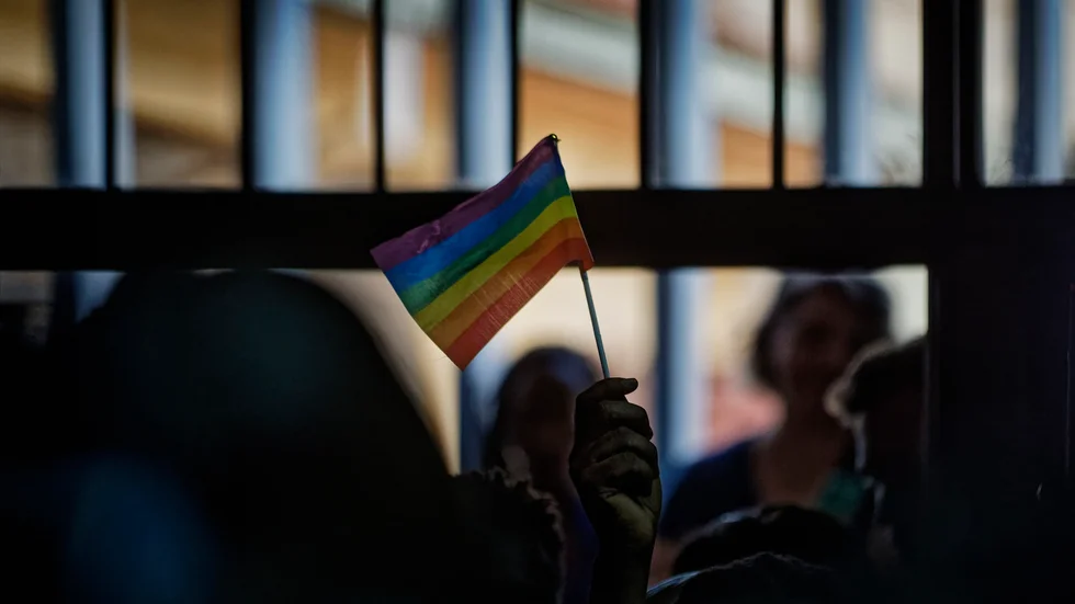 En hbtq-aktivist håller en regnbågsflagga i en rättssal i Kenyas huvudstad Nairobi 2019.