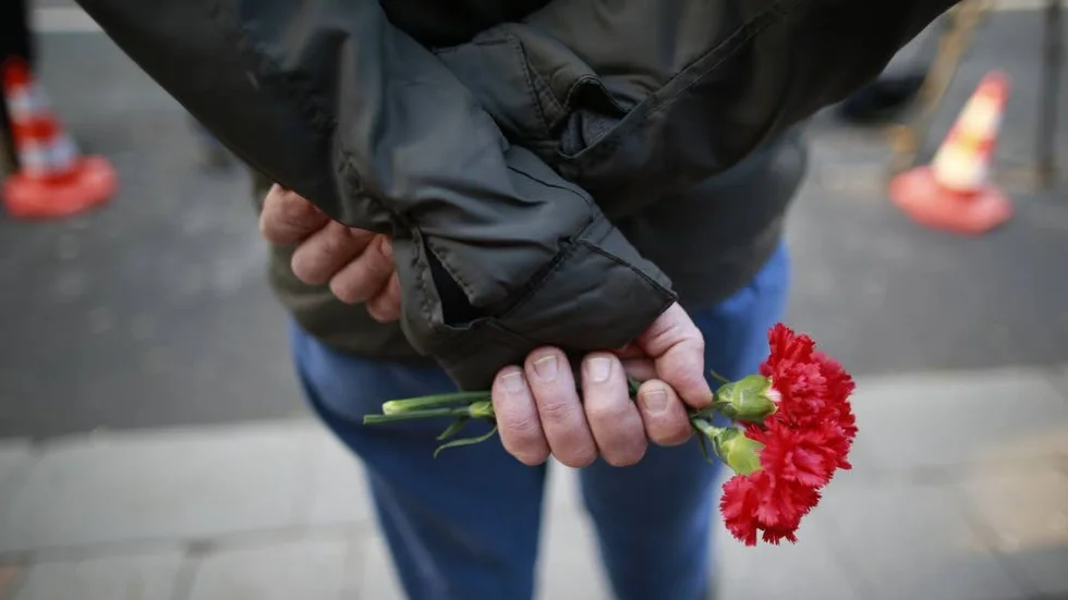 Blommor i Istanbul. En man väntar på att få hedra offren för nyårsnattens attentat.