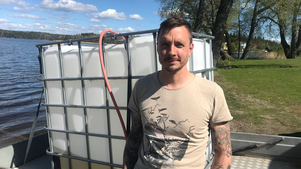 Robin Hird hämtar vatten från Frösjön för att vattna sin nylagda gräsmatta.