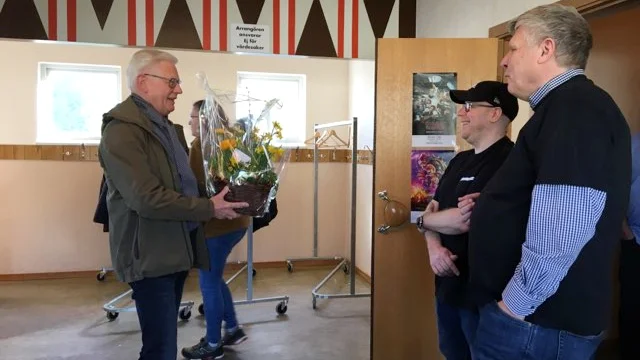 Anders Andersson från IOGT-NTO lämnade över en blomma till Peo Paulsson och Klas Liljegren, som ingår i styrelsen för Kulturhuset i Virserum, under påskhelgens öppet hus.