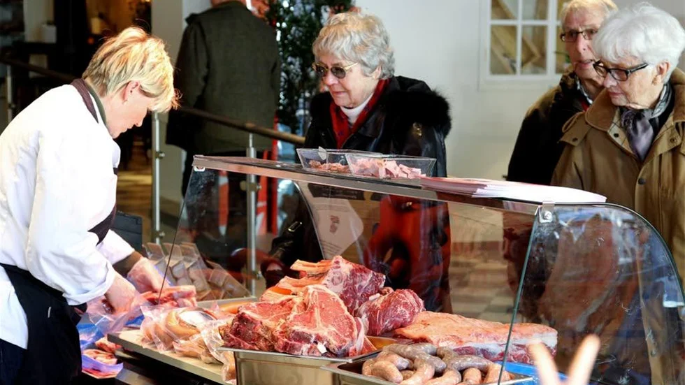 Birgitta Hjelm handlar lammkotletter av Britta Andersson i saluhallen på Storgatan i Linköping.