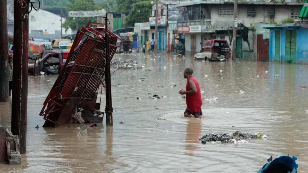 En man vadar genom vattenmassorna på de översvämmade gatorna i Port-au-Prince, Haiti.