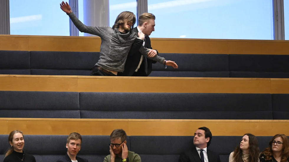 Mannen som protesterade fördes bort av vakter.