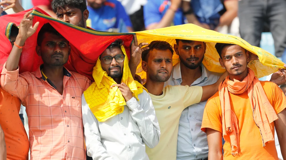 Cricketfans försöker skydda sig från värmen under en match i Lucknow i Indien den 22 april.
