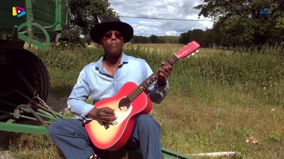 Eric Bibb spelar och sjunger en låt ute på landet.