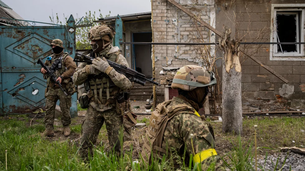 Ukrainska soldater undersöker en återtagen by i Charkivregionen i nordöstra Ukraina.