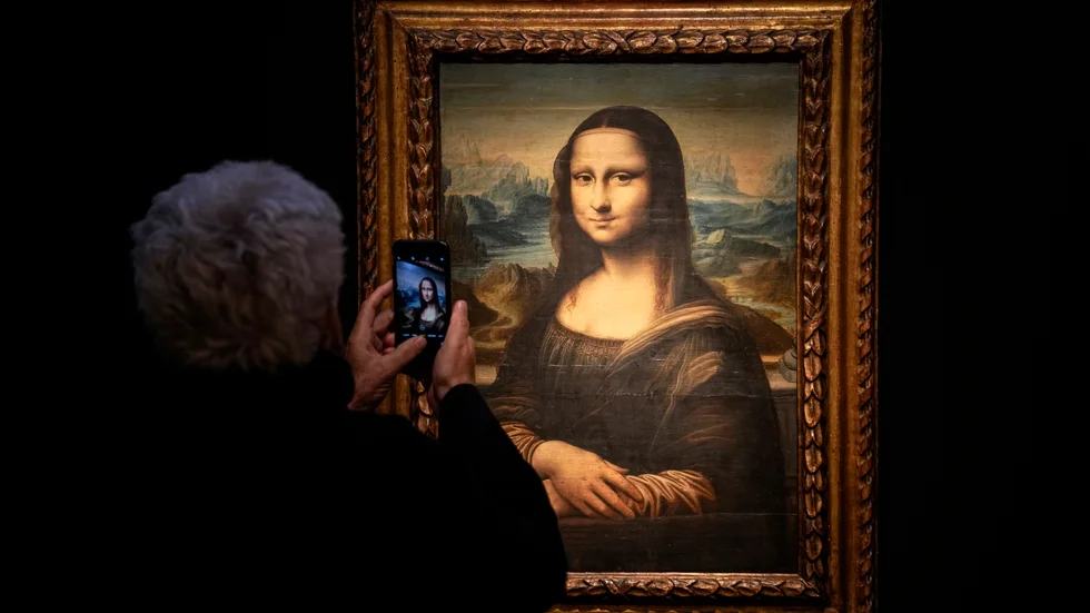 Mona Lisa blir fotograferad i Louvren i Paris. Arkivbild.