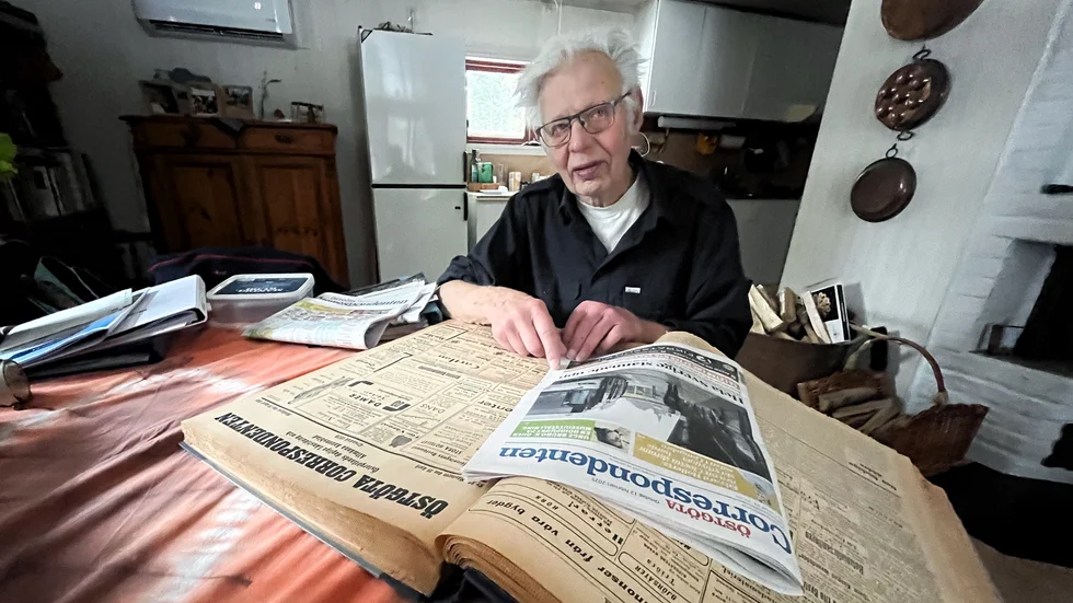 Stig Andersson sitter med en Correntidning från 1935. Året då han började läsa Corren. Ovanpå ligger ett nummer från 2025. Stig har nu varit en trogen läsare i 90 år. 