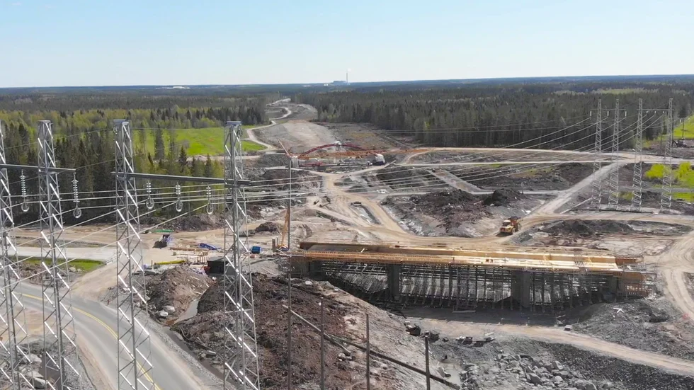 Arbetet pågår strax nedanför Ersmarksberget i Umeå. Främst syns en vägbro. Under den ska byggtrafiken gå, liksom under GC-bron en bit längre bort. I fjärran syns röken från Dåva industriområde.