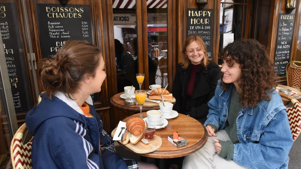 "En känsla av frihet". Så beskriver filmstudenten Lola Guilbaud (till höger) möjligheten att åter avnjuta en frukost på kafé. Här är hon tillsammans med Ines Piquet och Emma Hugon på kaféet Les Petites vid Place de la Contrescarpe i Paris.