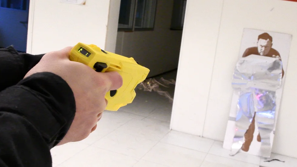Elchockvapnet avfyrar en pil med en tråd som leder el från vapnet. Arkivbild.
