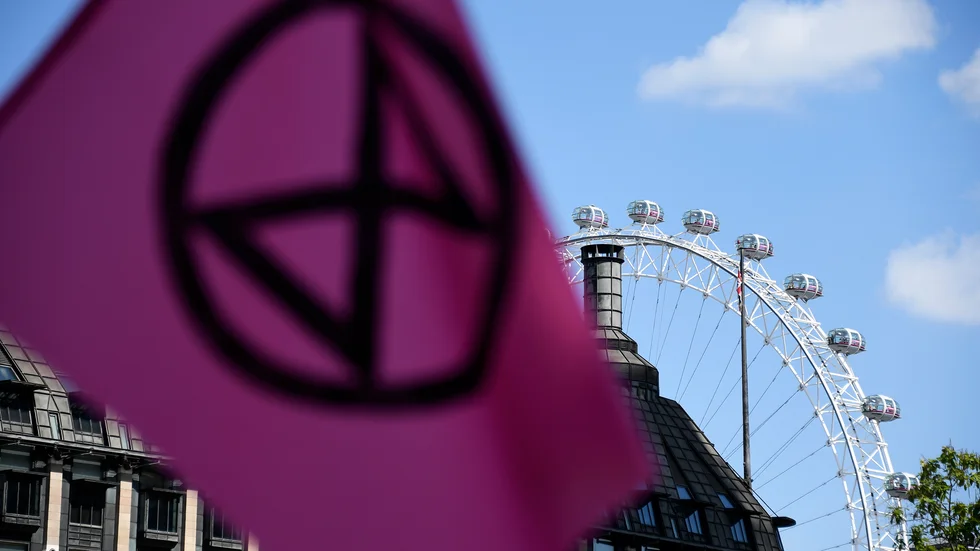En flagga från aktivistgruppen Extinction Rebellion vajade i centrala London under en protest i september i fjol. Arkivbild.