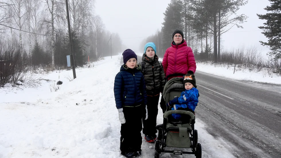 Längs vägen där barnen väntar på bussen är hastighetsbegränsningen 90 kilometer i timmen och det passerar fullastade timmar bilar. "Det känns inte tryggt", säger Erika Modig här med barnen Alma 7 år, Sixten 9 år, och Eskil 1 år