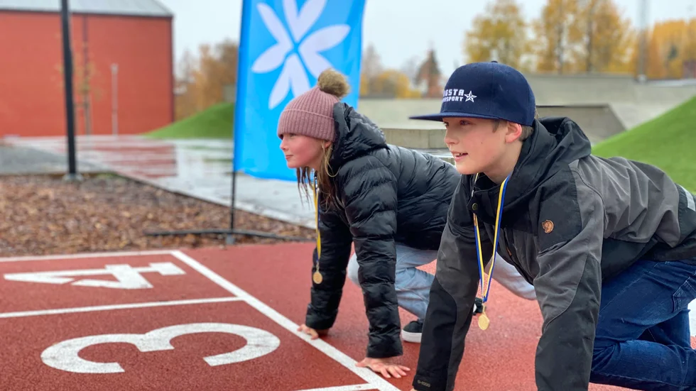 Kate Lindström och Edward Eriksson gör sig redo för 60-metersloppet på Arenaparken i Norsjö. Efteråt belönades de med guldmedalj.