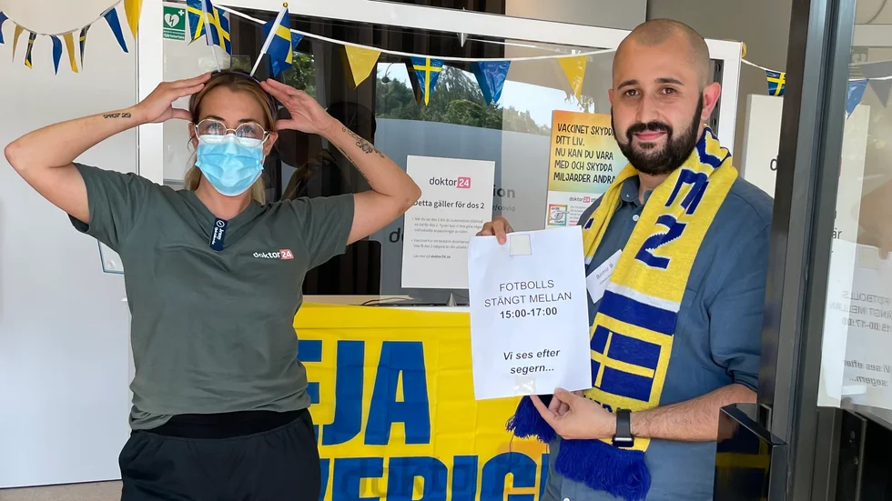 Jenny och Bemir med skylten som satte vaccinationskliniken i Oxelösund på kartan. 