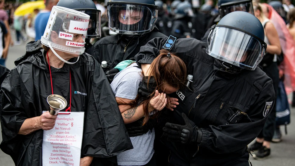Polis griper en demonstrant under en otillåten demonstration i Berlin på söndagen.