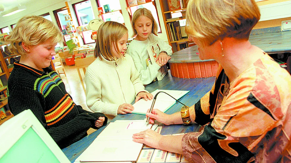 Moa Niemi, Emily Larsson och Sofie Ökvist premiärlånade på nyöppnade barnbiblioteket i Porsö centrum. Här får de hjälp av bibliotekarie Berit Forsberg.