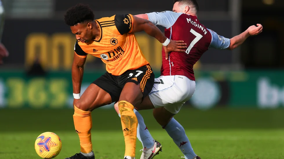 Wolverhamptons Adama Traore, till vänster, i duell med Aston Villas John McGinn.