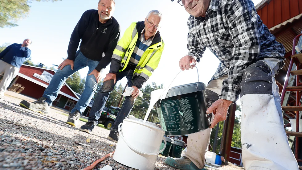 Anders Gillstrand och Hans Zentio är redo att gå loss på de nyskrapade husknutarna och väntar på att Bertil Zentio ska dosera upp rätt mängd färg i deras hinkar.