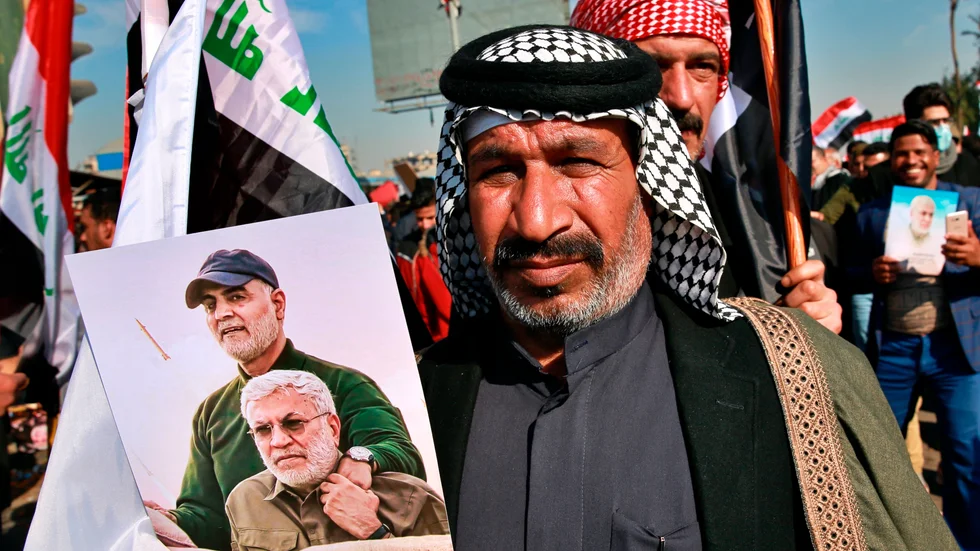 En anhängare till den irakiska milisen Hashid al-Shaabi med en bild på dess tidigare befälhavare Abu Mahdi al-Muhandis och den iranske generalen Qassem Soleimani.