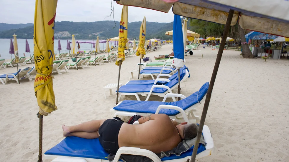 En turist solar i Patong i Phuket i Thailand. Nu gör sig landet redo för att försiktigt öppna för ett begränsat antal turister. Arkivbild.