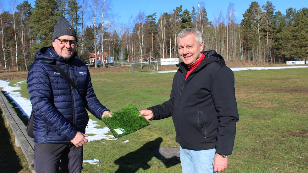 Patric Sjöblom och Sören Karlsson med en bit av den sortens konstgräs som ska "växa" på Hammarvallen framöver.