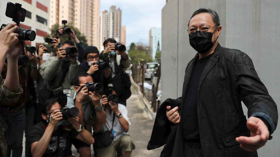 Demokratiförespråkaren Benny Tai pratar med pressen utanför en polisstation i Hongkong på söndagen.