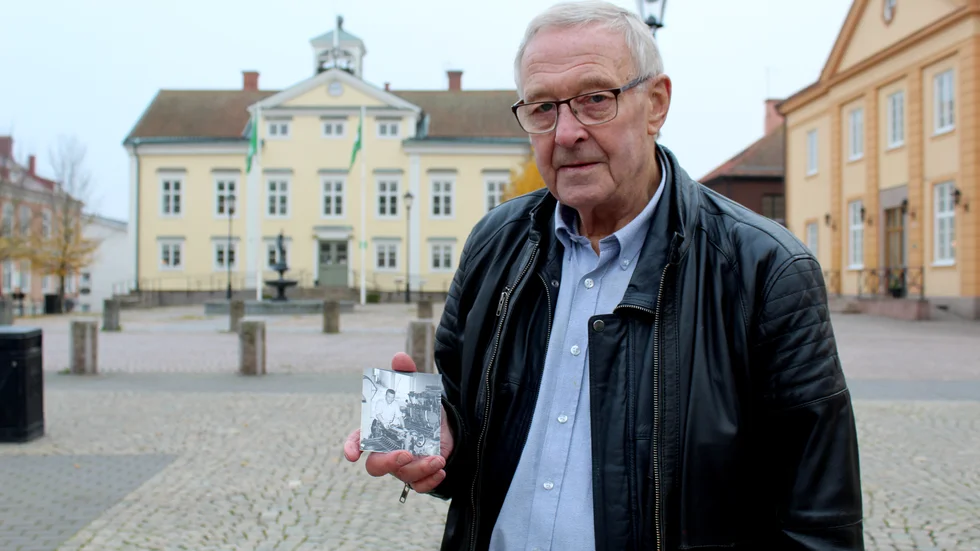 Olle Larsson håller i en bild från när han jobbade som grafiker på Vimmerby Tidning. Tryckpressen som syns på bilden är samma sort som han nu tryckt sin bok i. 
