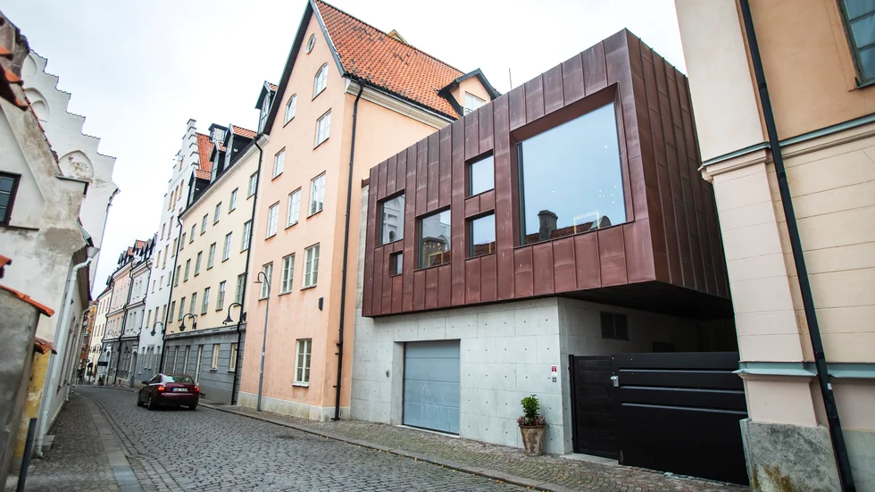 25 meter från detta relativa nytillskott i innerstaden, får ett äldre hus inte ges sin ursprungliga färg.