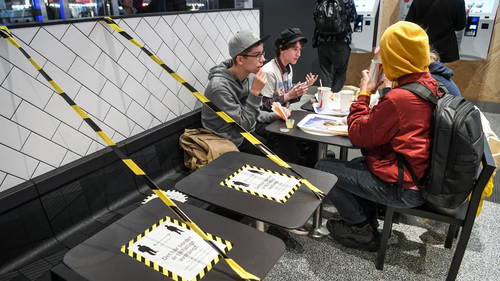 Ungdomar på en coronasäkrad snabbmatsrestaurang, med avspärrade bord för att säkra att avstånd hålls för att hindra smittspridning under coronapandemin. Arkivbild.
